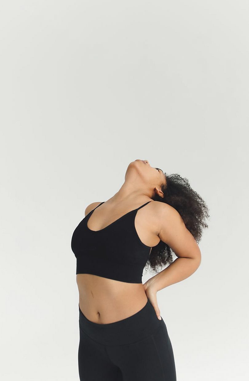 Woman in a black wire-free bralette tilting her head back
